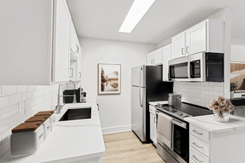 A kitchen with white cabinets and stainless steel appliances